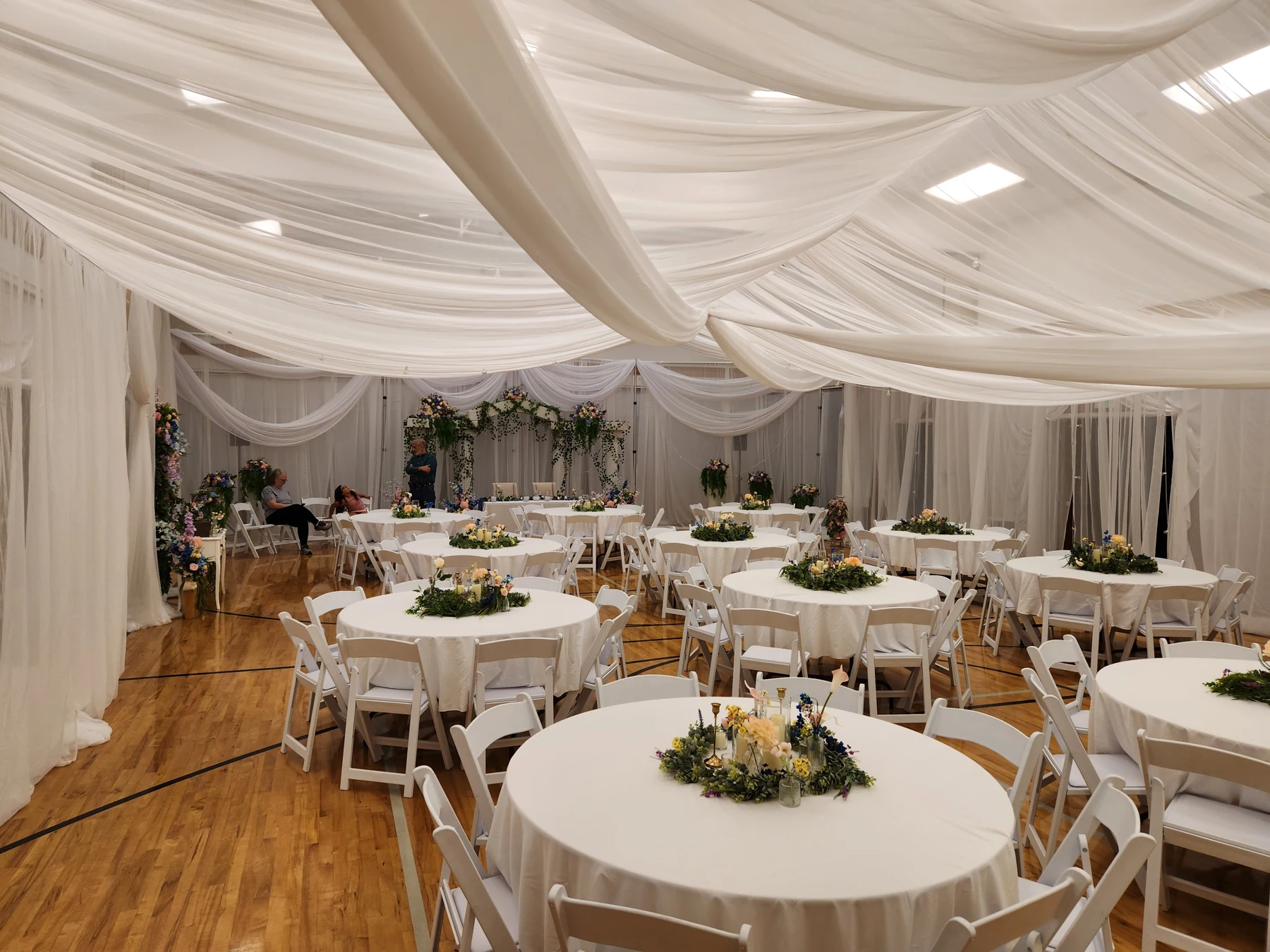 Draped canopy above fully dressed round tables and floral centerpieces. Meridian, Idaho.