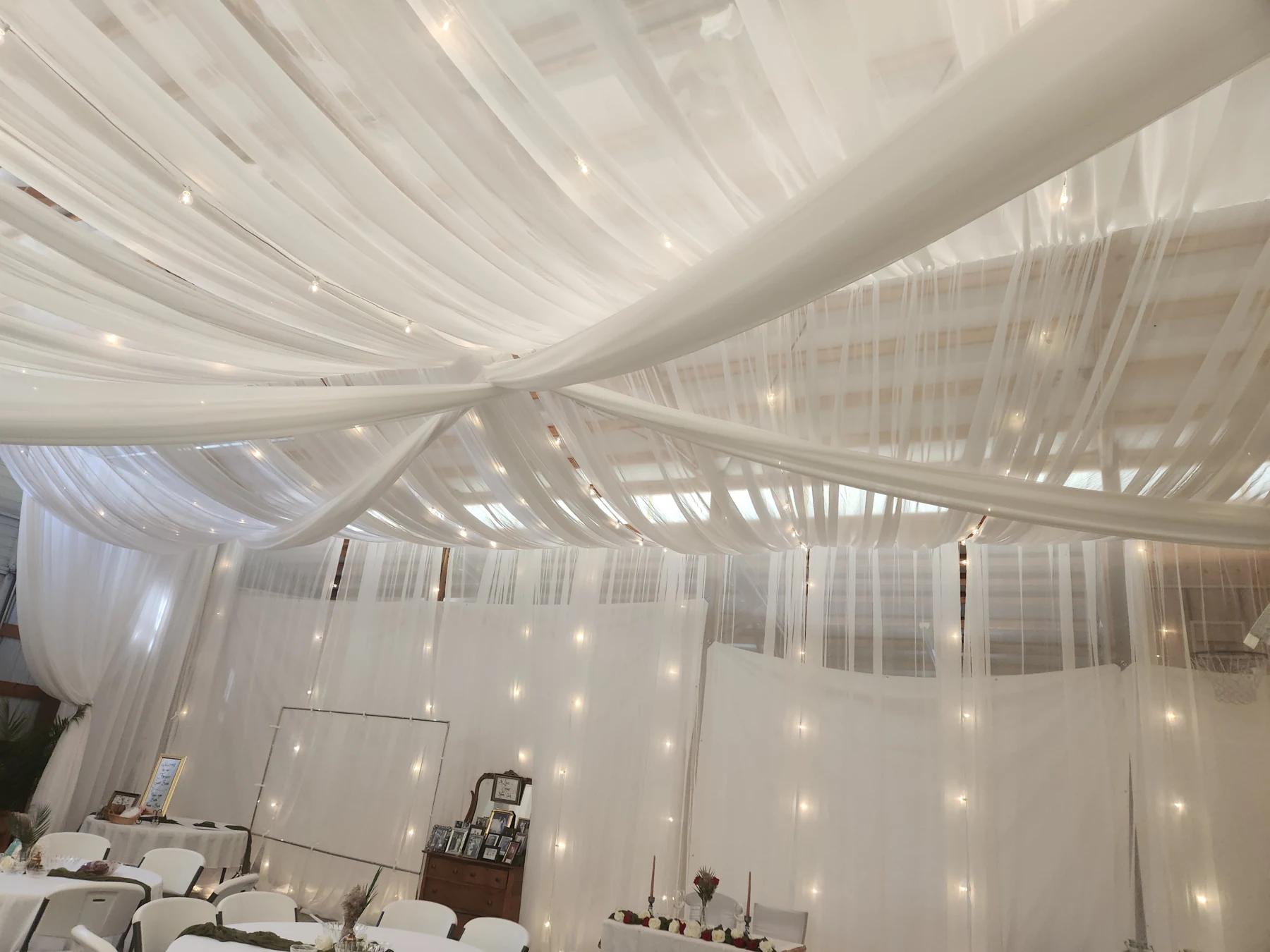 An intimate workshop space transformed with draping, lights and round tables. Kuna, Idaho.