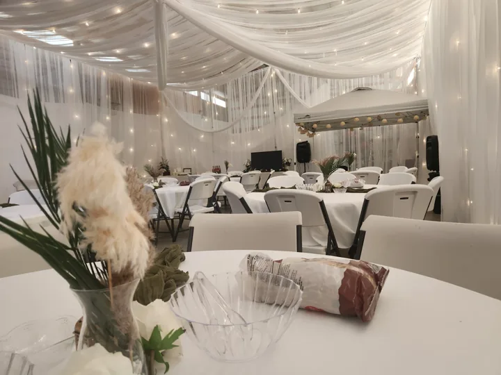 Floral centerpiece and candle details beneath the white canopy.