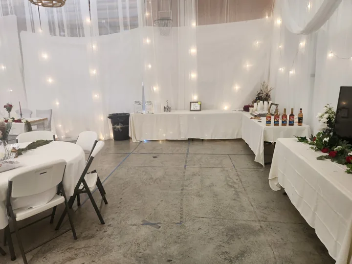 The serving area framed by white draping and warm string lights.