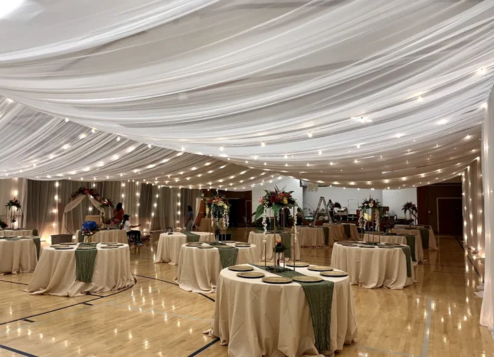 A wide view across a fully dressed cultural-hall reception.