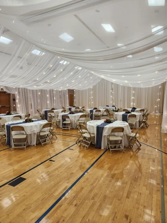 Round tables beneath a white canopy in a Utah reception.