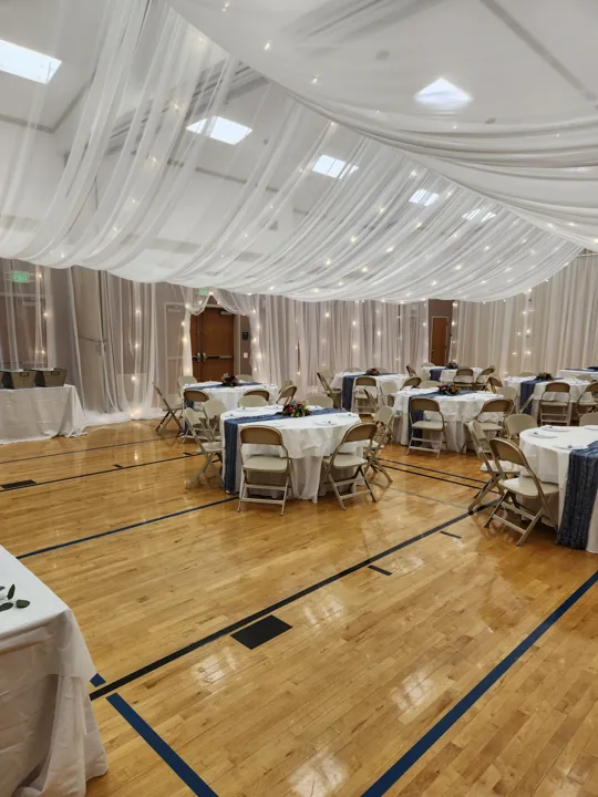 The finished room with reception tables and ceiling draping.